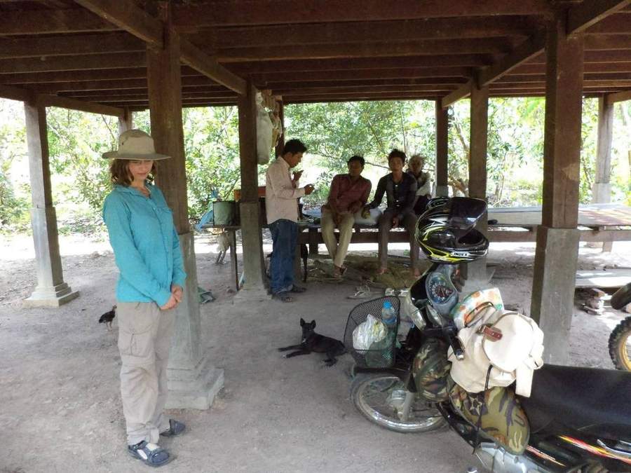 Volunteers and Cambodian children sitting together outdoors in rural village