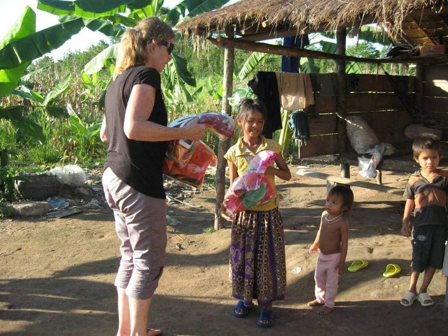 Volunteer distributing supplies to children in village