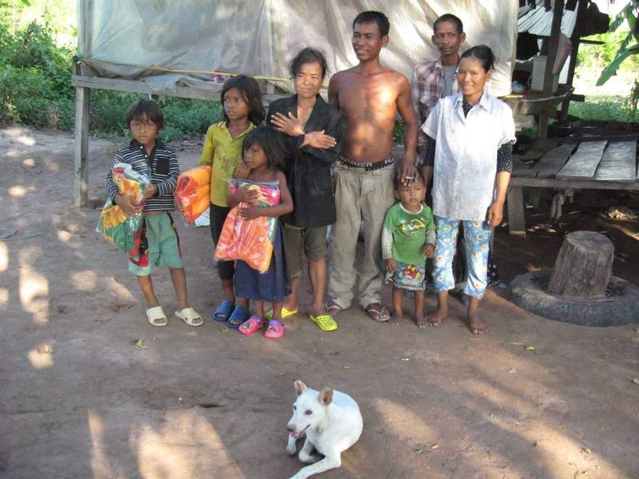 Family posing together outside their home with dog