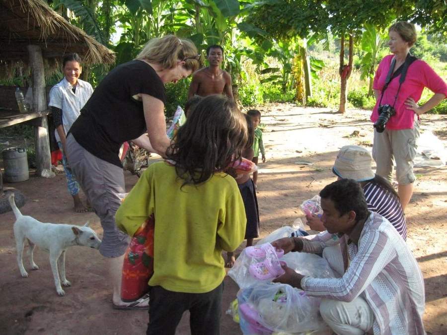 Volunteer giving clothes to children in rural village