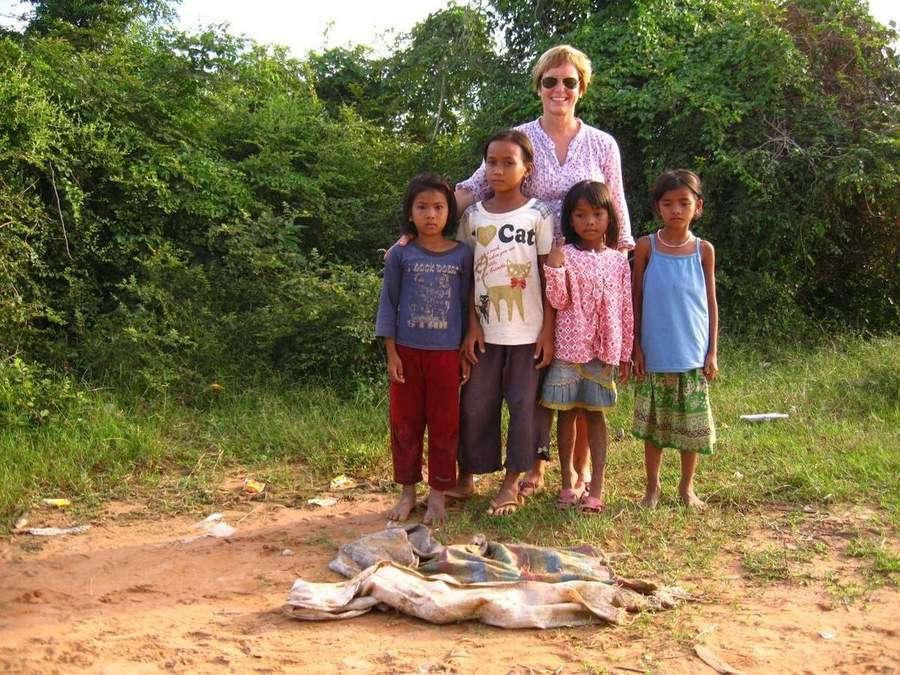 Volunteer standing with four girls in grassy area