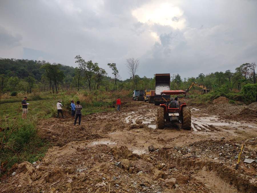 Muddy construction site with tractor trucks and workers