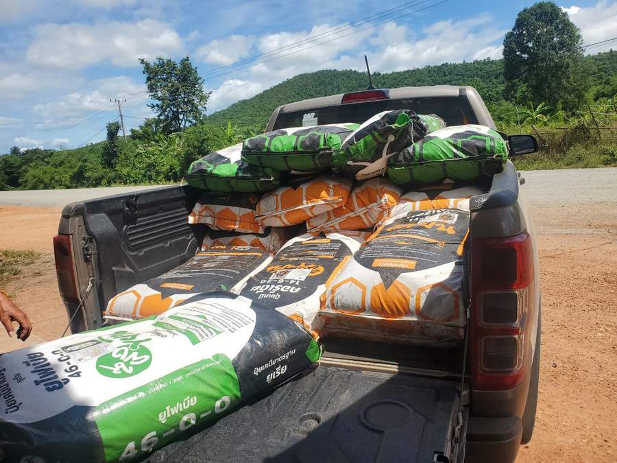 Pickup truck loaded with bags of fertilizer on dirt road