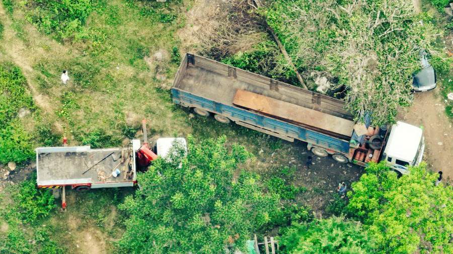 Aerial view of trucks parked on forest road
