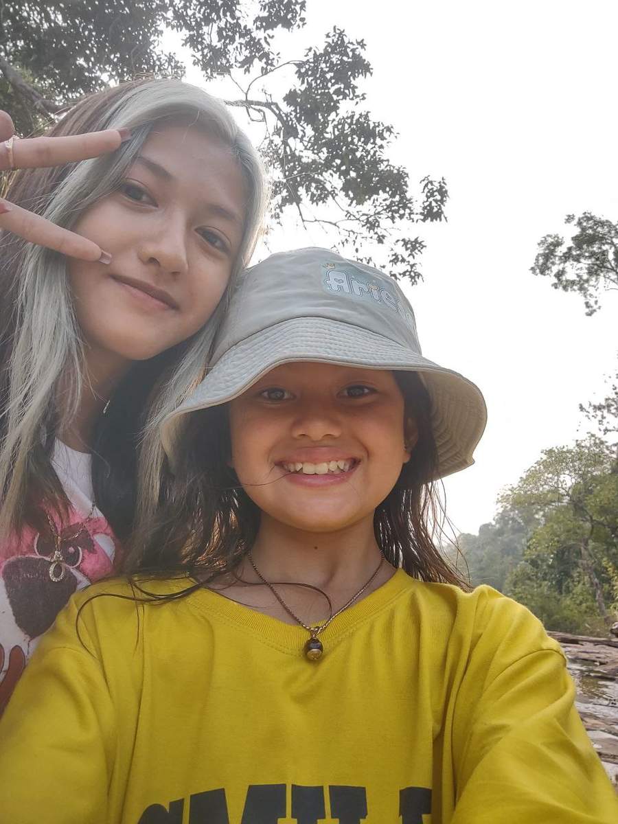Two young women taking selfie with forest backdrop