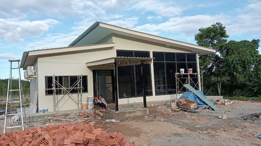 Building under construction with scaffolding and brick pile