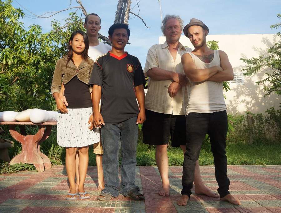 Group of five people posing together outdoors