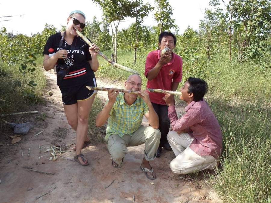 Volunteers walking on sidewalk in town near market stalls