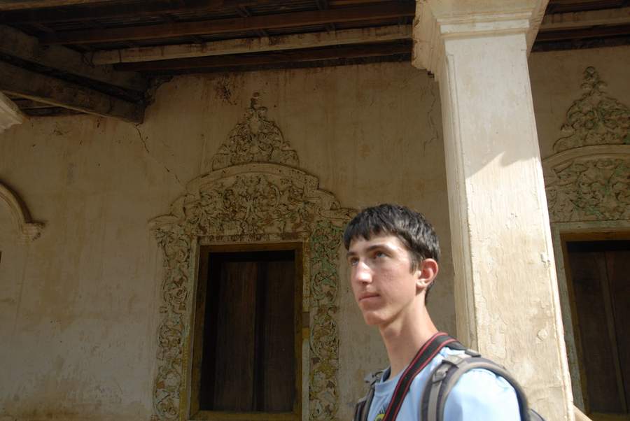 Young man standing in front of ornate carved doorway