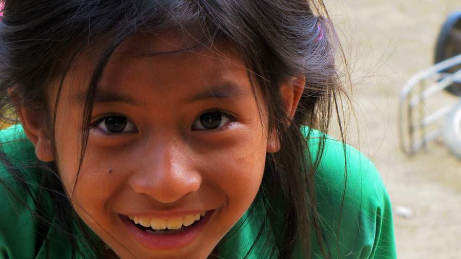 Close-up of young girl smiling in green shirt
