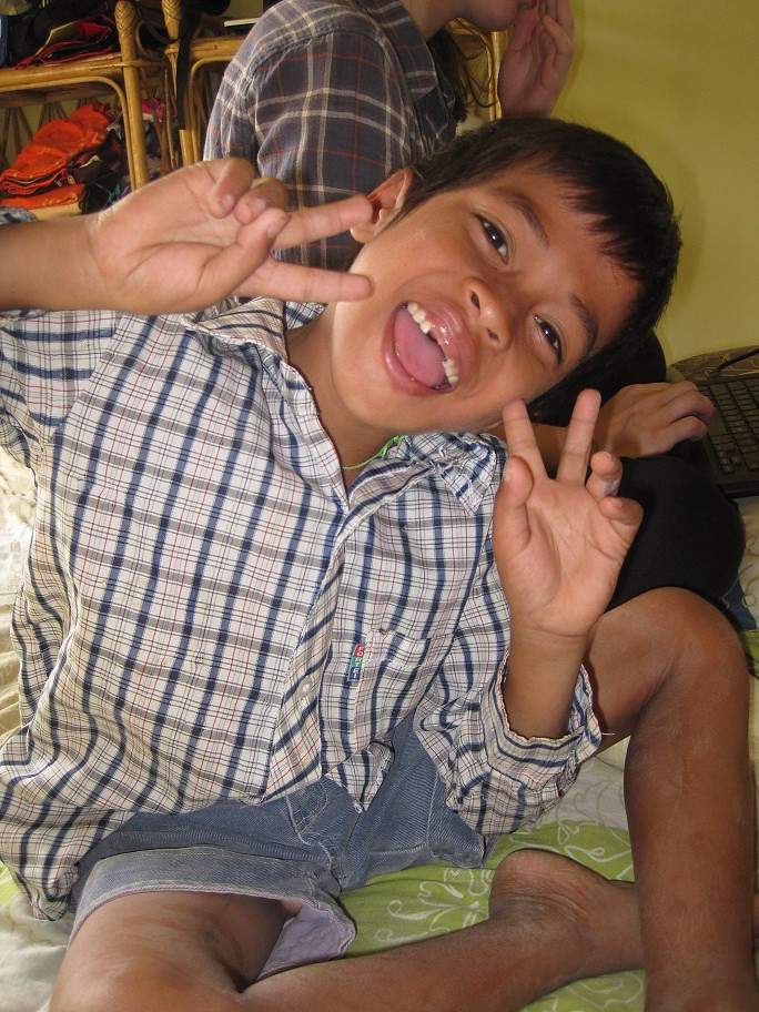 Young boy making funny face with peace signs