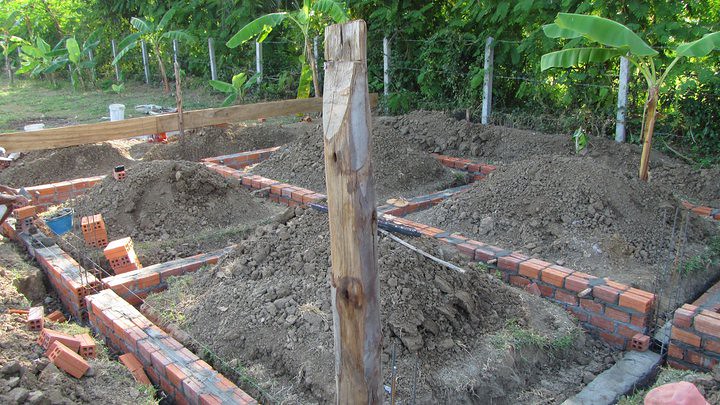 Foundation trench with brick walls and wooden post