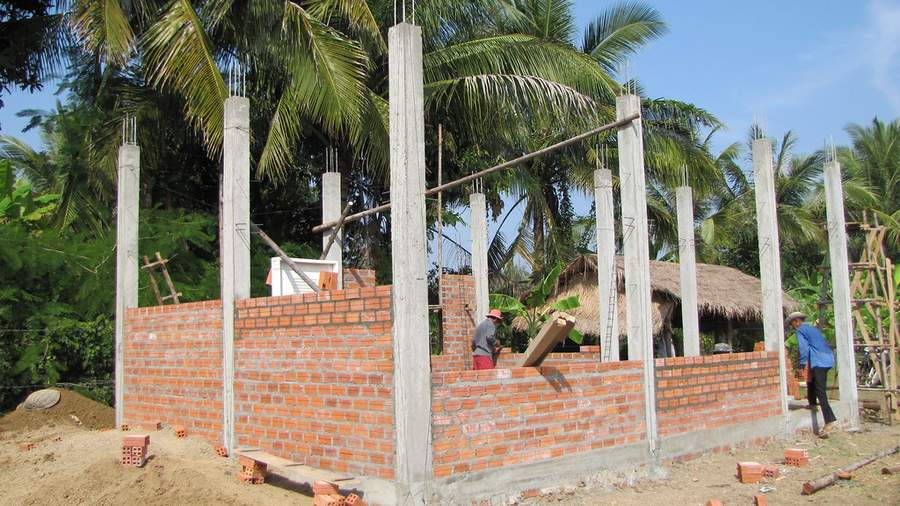 Brick building under construction with concrete pillars