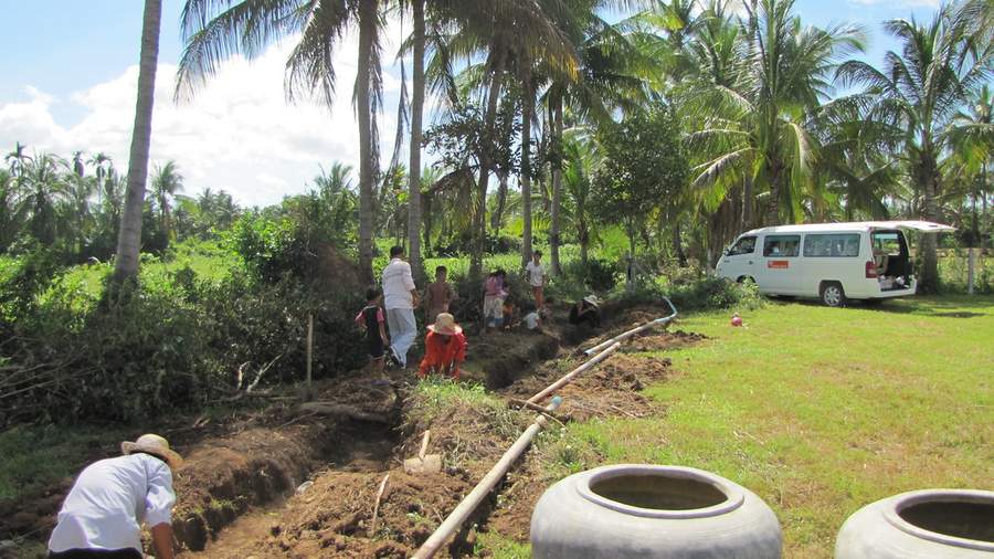 People working in trench with pipes and white van