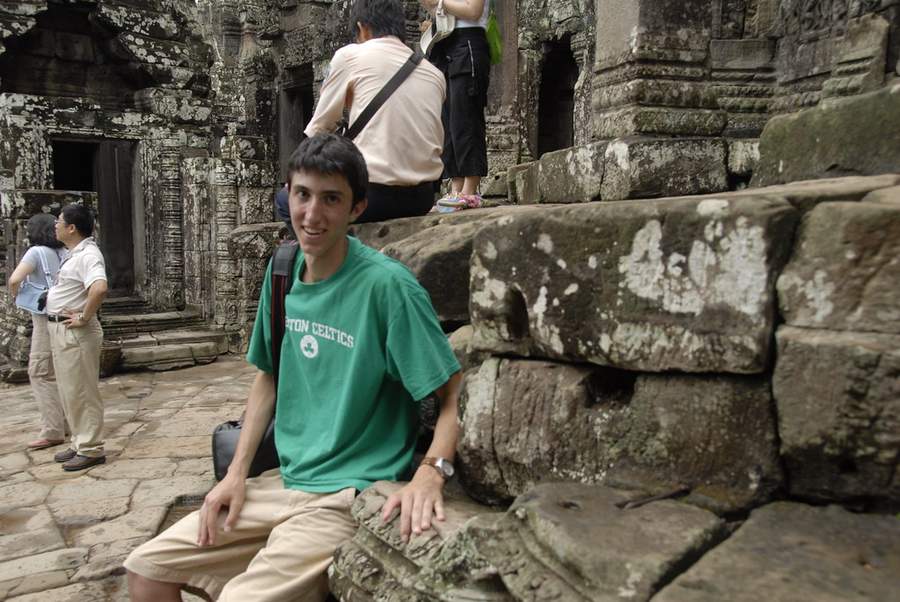 Young man in green Boston Celtics shirt at ancient stone temple