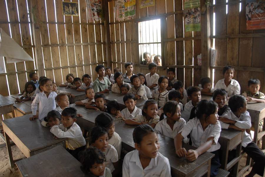 Students at desks in wooden slat classroom looking forward