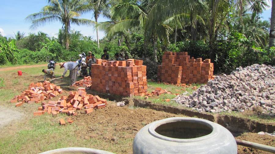 Workers laying bricks and sorting materials at construction site