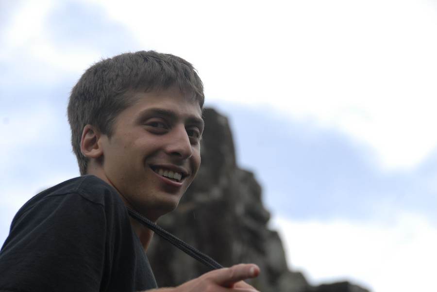 Young man smiling at ancient stone temple