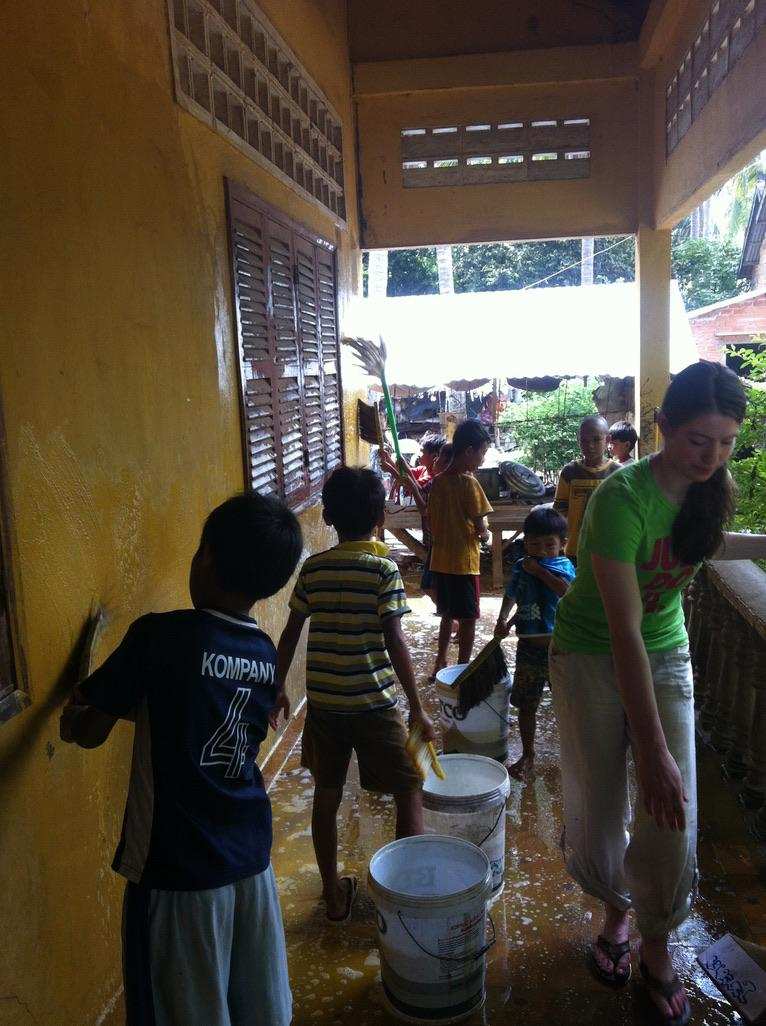 Children helping wash walls during school renovation