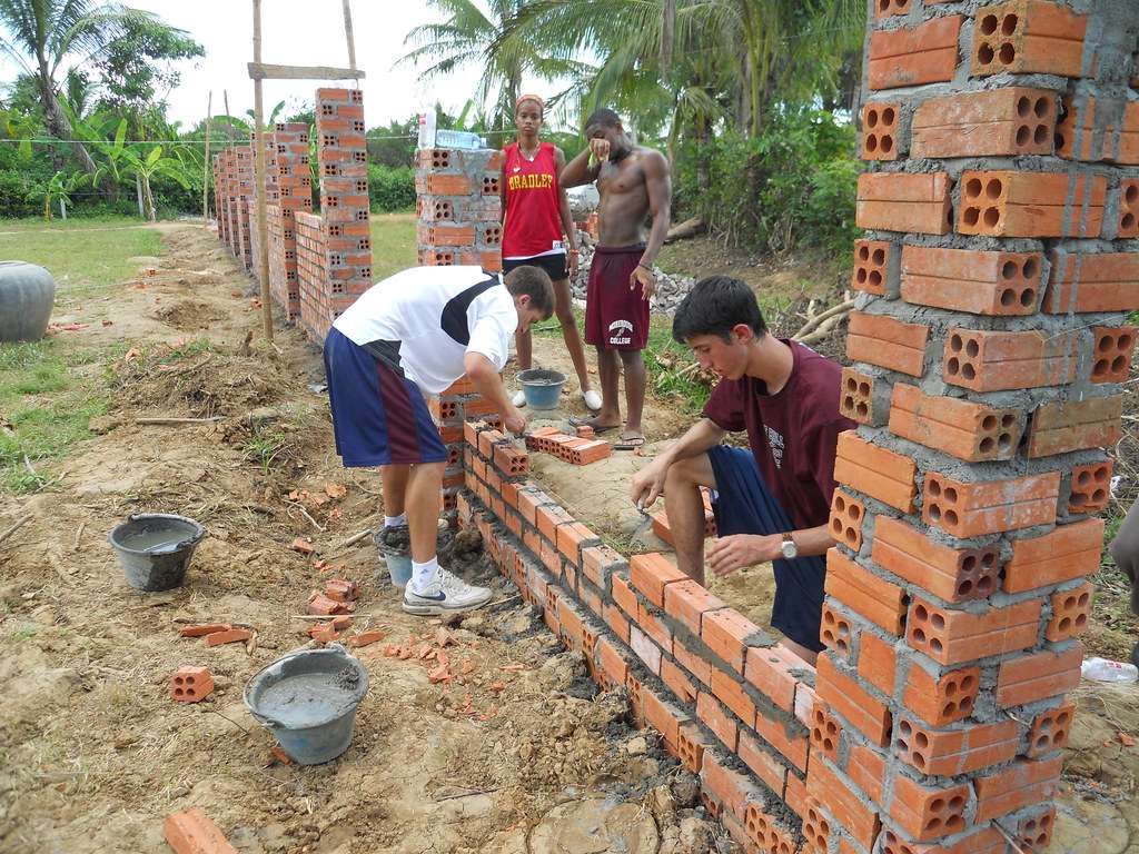 Volunteers building a brick wall at a community project